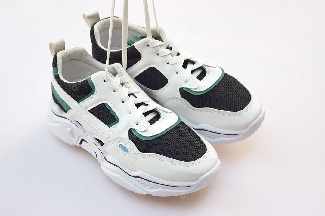 Par de tênis femininos brilhantes em fundo rosa claro