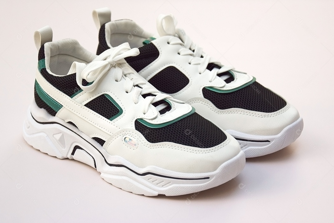 Par de tênis femininos brilhantes em fundo rosa claro