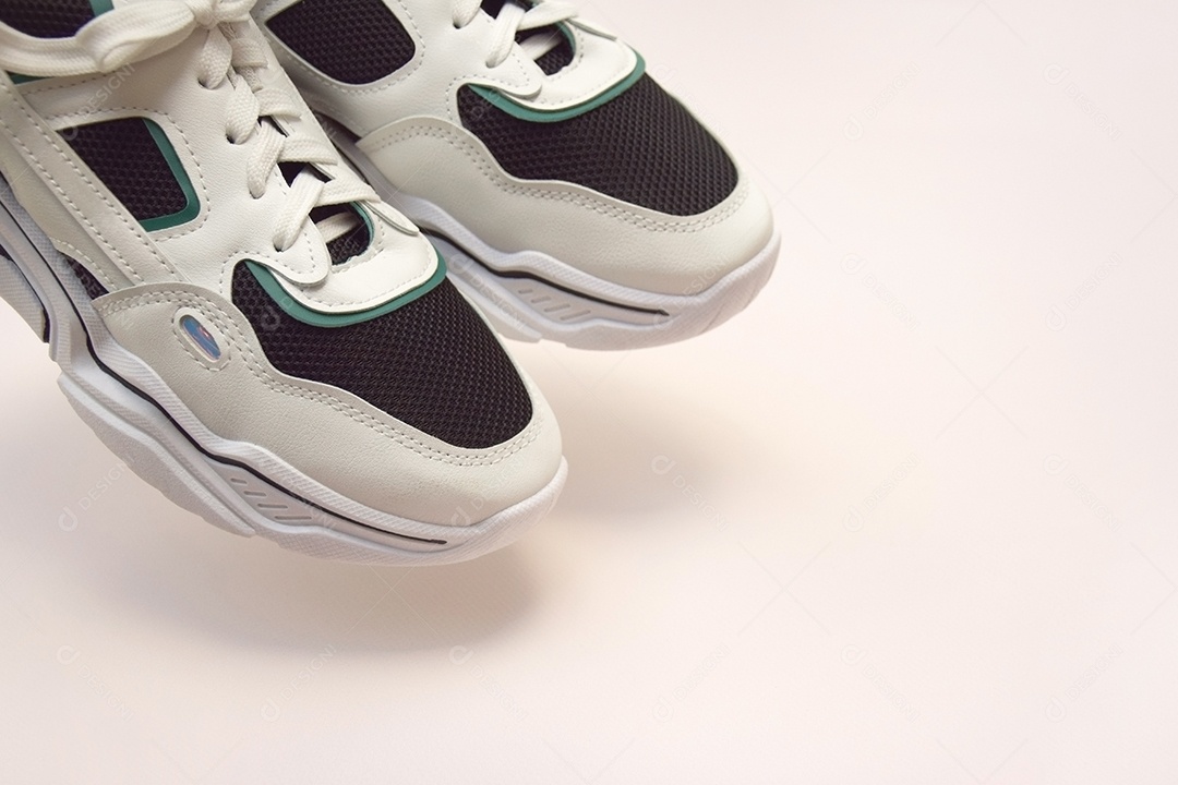 Tênis femininos brilhantes em fundo rosa claro