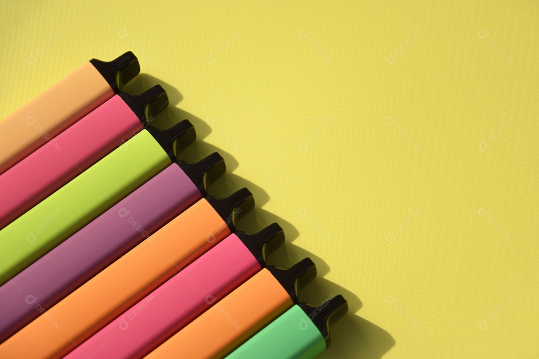 Muitos cigarros eletrônicos descartáveis ​​multicoloridos em um fundo amarelo