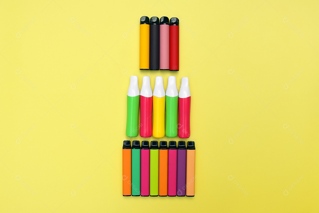 Muitos cigarros eletrônicos descartáveis ​​multicoloridos em um fundo amarelo brilhante