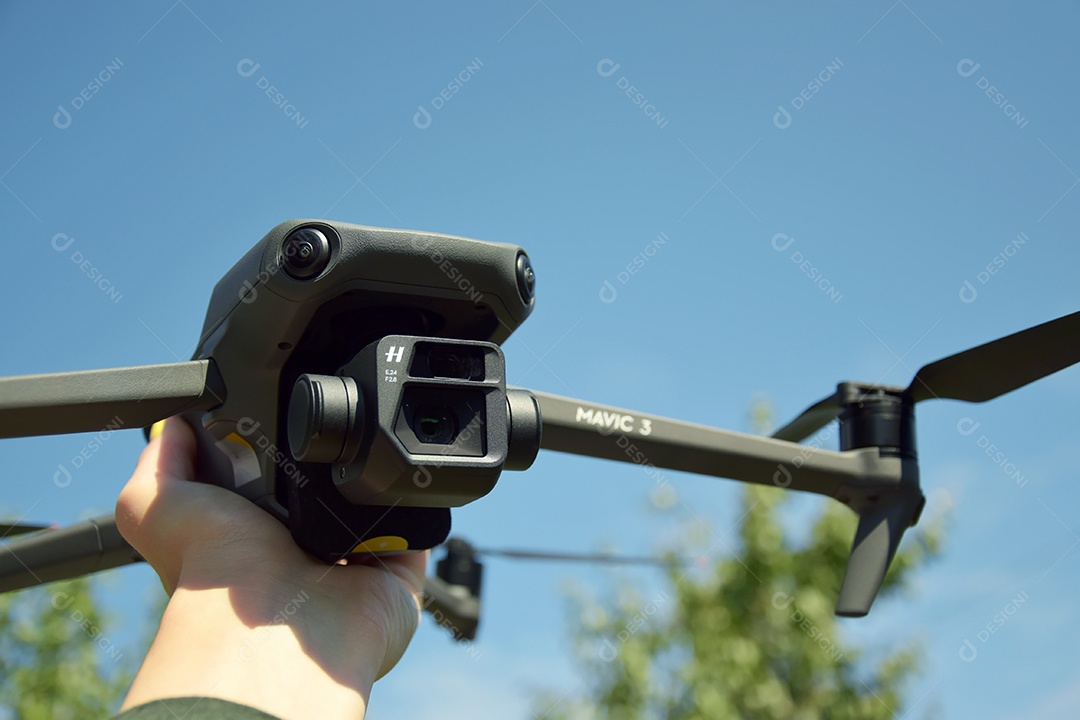 Mão segurando drone mavic 3 contra céu azul