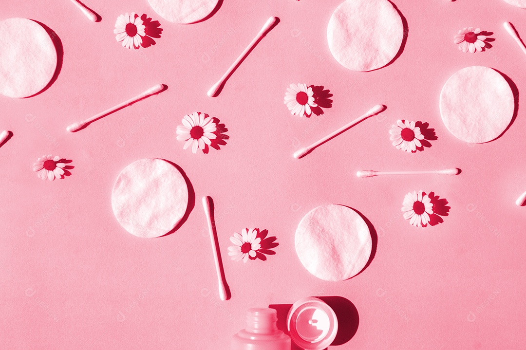 Cotonetes e disco de algodão e flor de camomila sobre fundo magenta