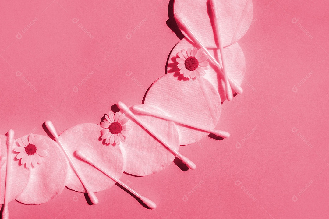 Cotonetes e disco de algodão e flor de camomila sobre fundo magenta
