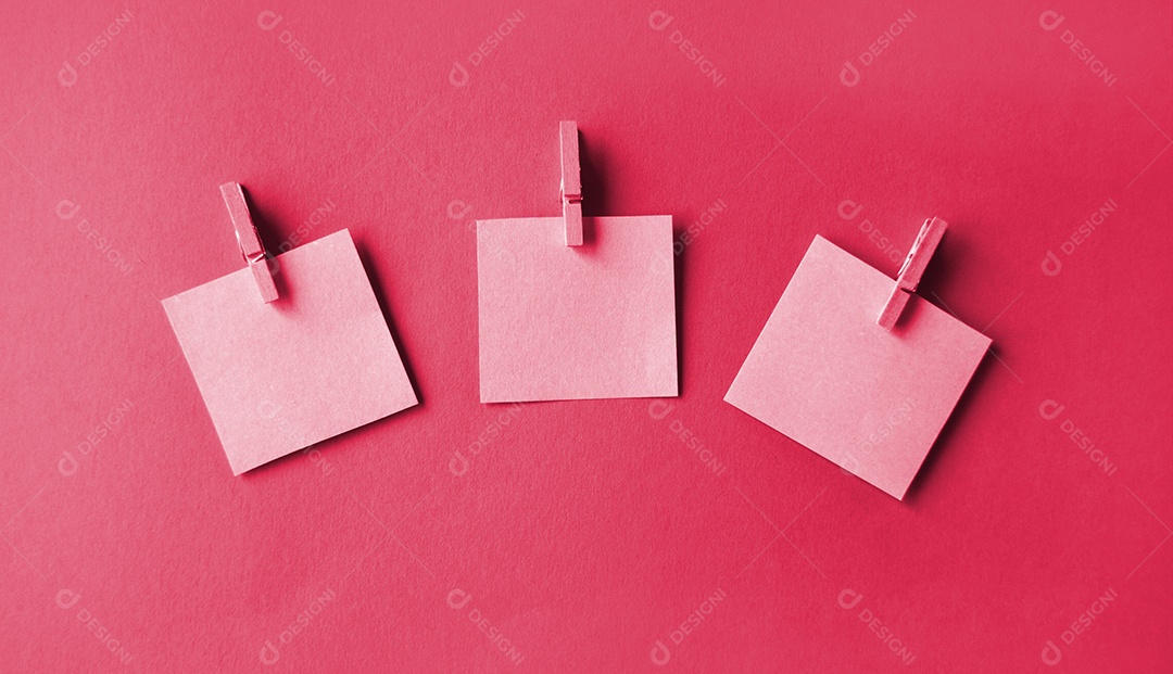 Prendedores com post it pregados  sobre fundo magenta