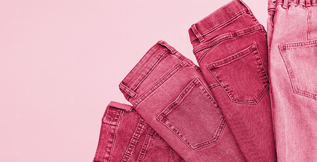 Calças jeans dobradas em fundo magenta