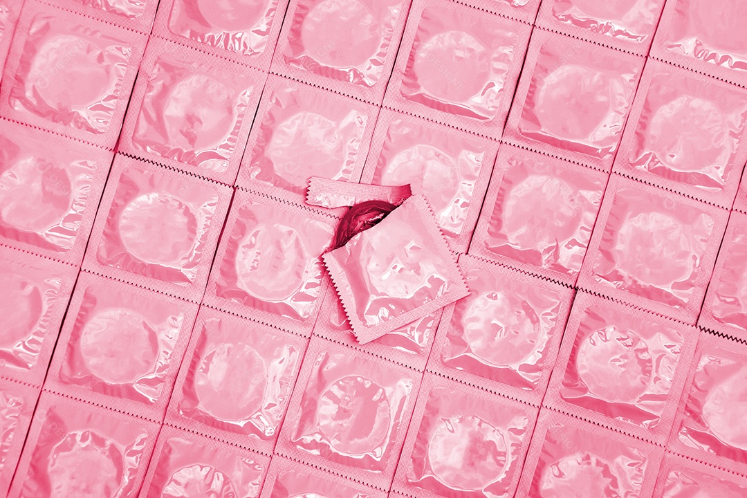 Vários preservativos sobre fundo rosa claro
