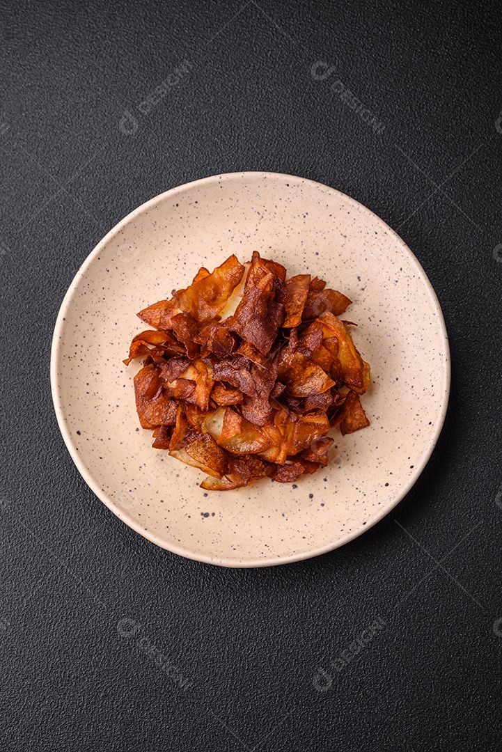Deliciosas batatas fritas crocantes com sal e especiarias em um fundo escuro de concreto