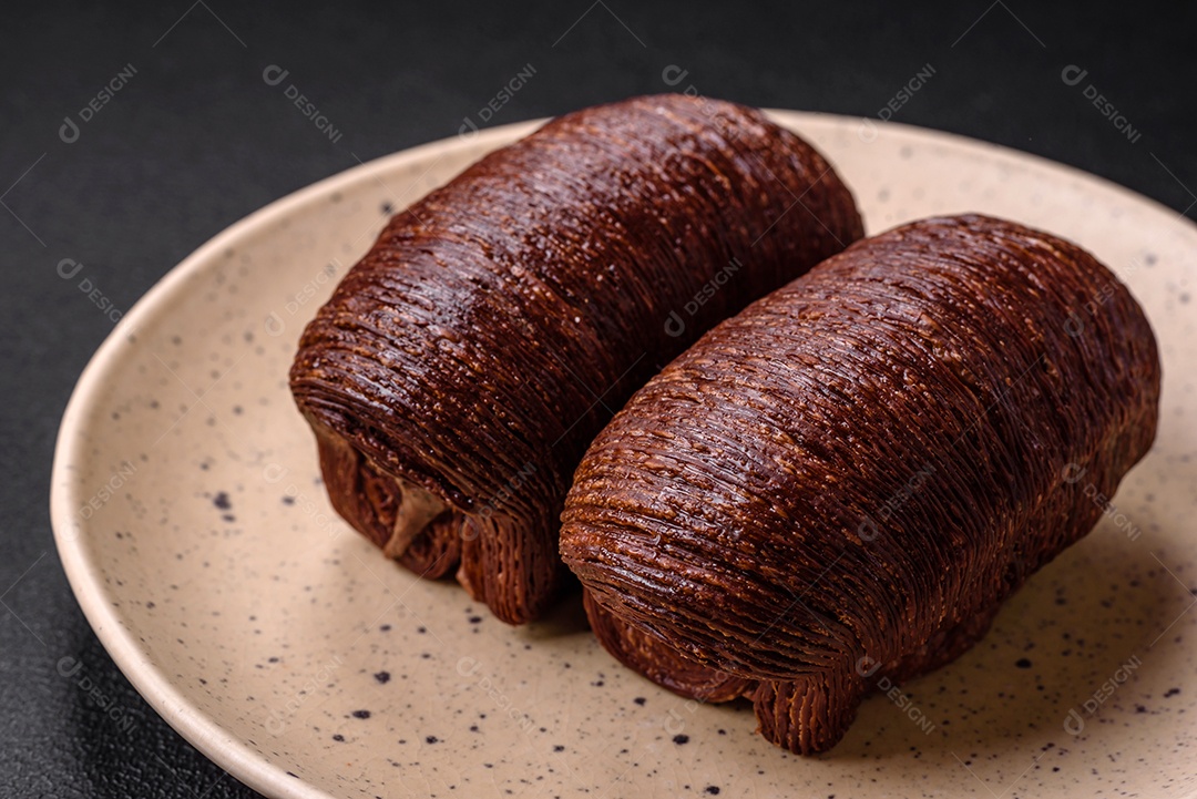 Deliciosa massa folhada crocante e doce com recheio de chocolate sobre um fundo escuro de concreto