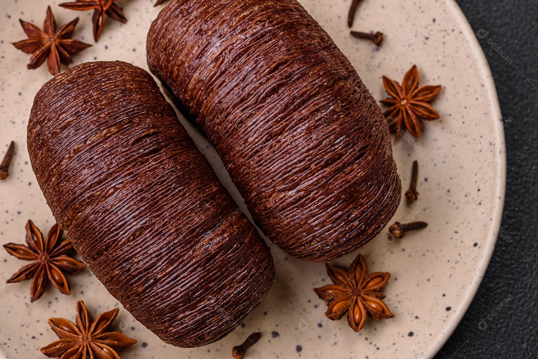 Deliciosa massa folhada crocante e doce com recheio de chocolate sobre um fundo escuro de concreto