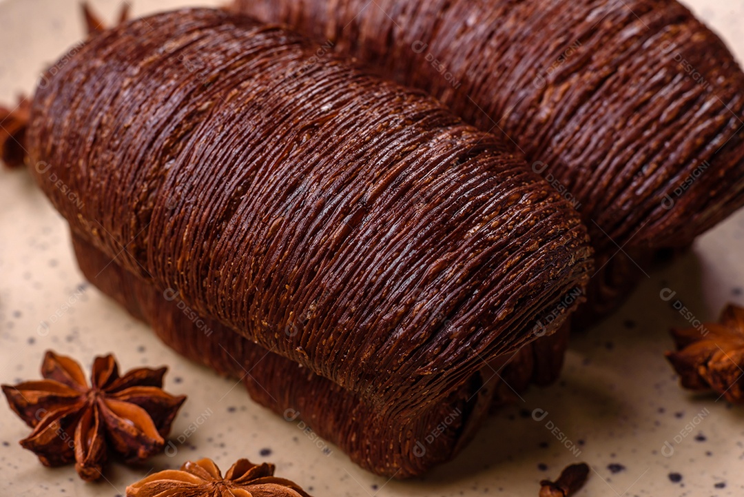 Deliciosa massa folhada crocante e doce com recheio de chocolate sobre um fundo escuro de concreto