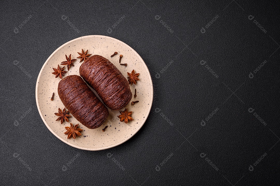 Deliciosa massa folhada crocante e doce com recheio de chocolate sobre um fundo escuro de concreto