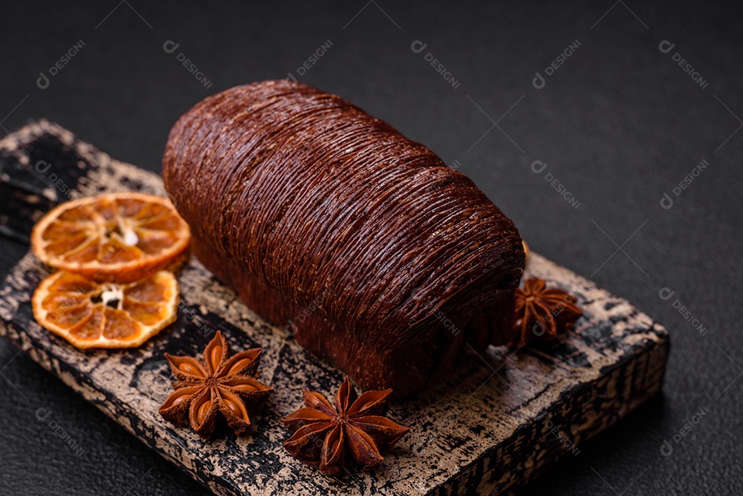 Deliciosa massa folhada crocante e doce com recheio de chocolate sobre um fundo escuro de concreto