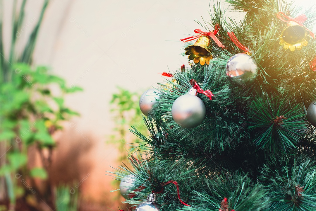Segurando uma taça de vinho com árvore de Natal no fundo do quintal