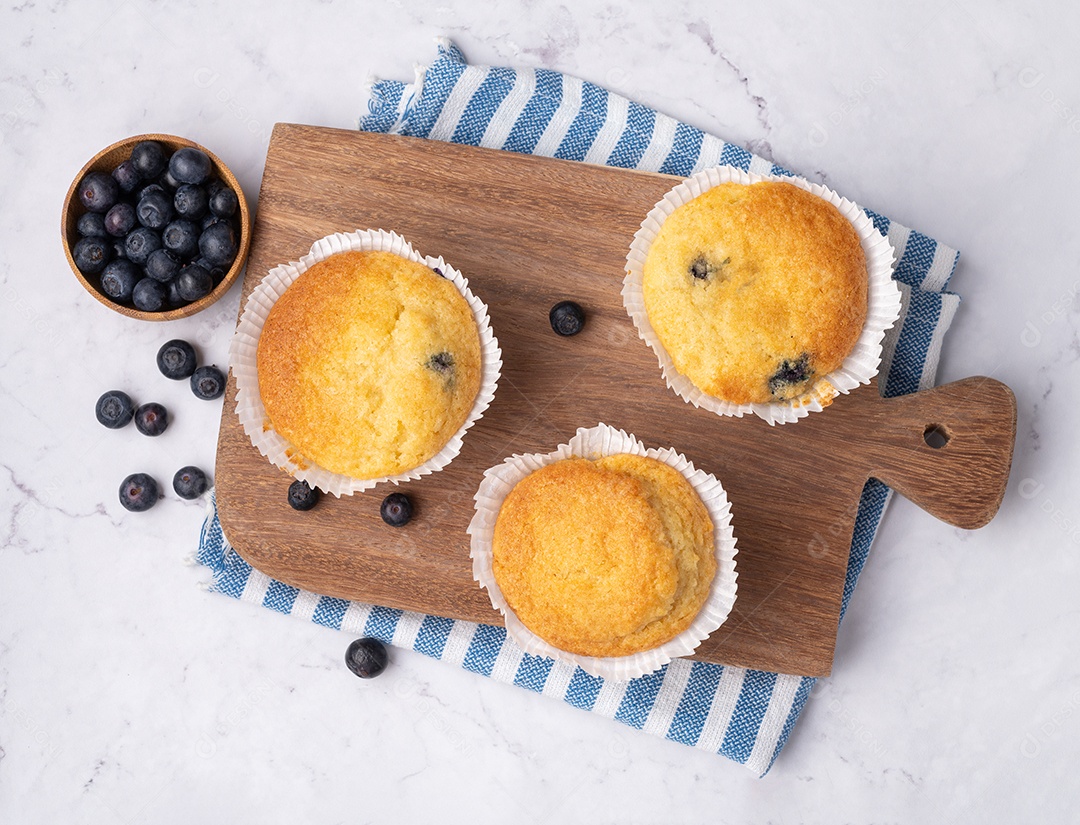 Muffins de mirtilo com frutas sobre tábua de madeira