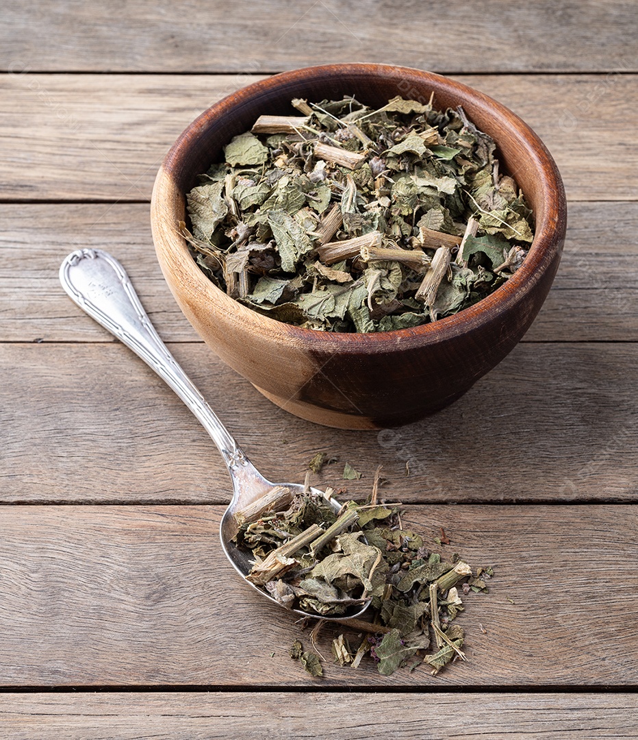 Erva-cidreira ou folhas de chá secas de Melissa em uma tigela sobre a mesa de madeira.