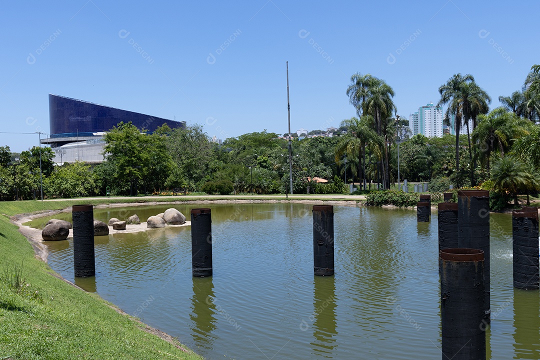 Lagoa de um parque com muitas árvores ao redor.
