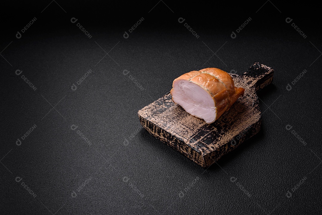 Deliciosa carne de porco ou frango defumada com sal, especiarias e ervas sobre um fundo escuro de concreto