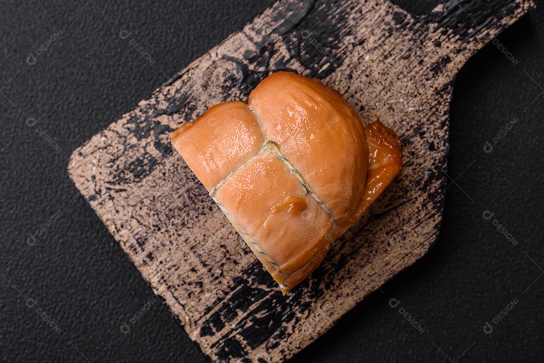 Deliciosa carne de porco ou frango defumada com sal, especiarias e ervas sobre um fundo escuro de concreto