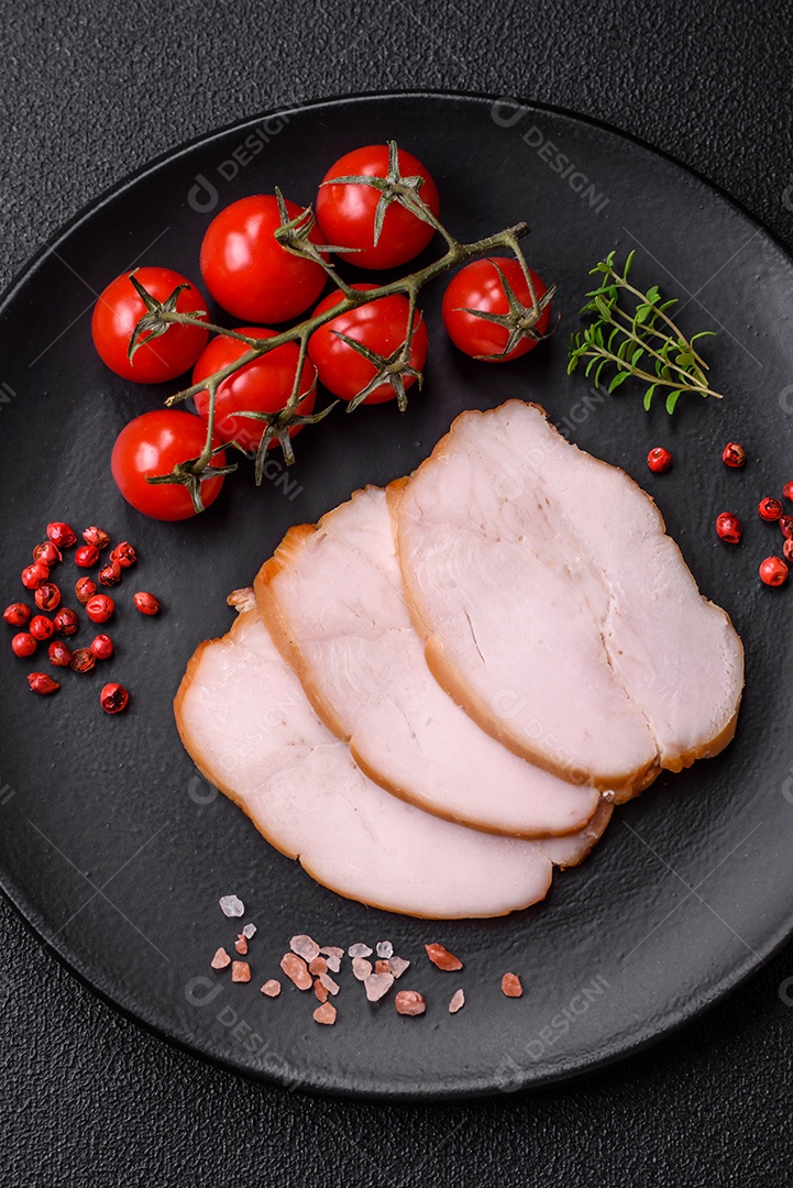 Deliciosa carne de porco ou frango defumada com sal, especiarias e ervas sobre um fundo escuro de concreto