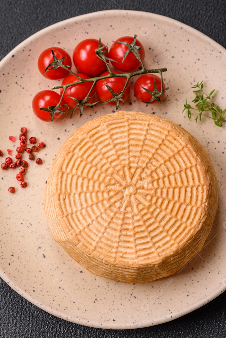 Delicioso queijo artesanal feito de leite de vaca ou cabra sobre um fundo escuro de concreto