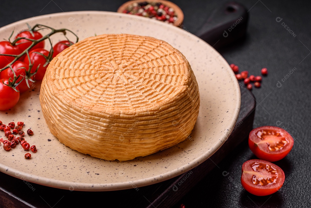 Delicioso queijo artesanal feito de leite de vaca ou cabra sobre um fundo escuro de concreto