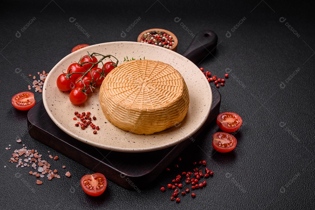 Delicioso queijo artesanal feito de leite de vaca ou cabra sobre um fundo escuro de concreto