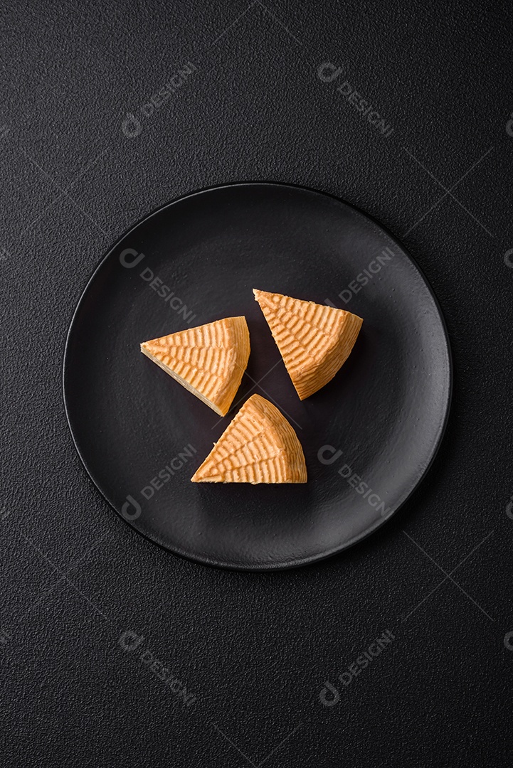 Delicioso queijo artesanal feito de leite de vaca ou cabra sobre um fundo escuro de concreto