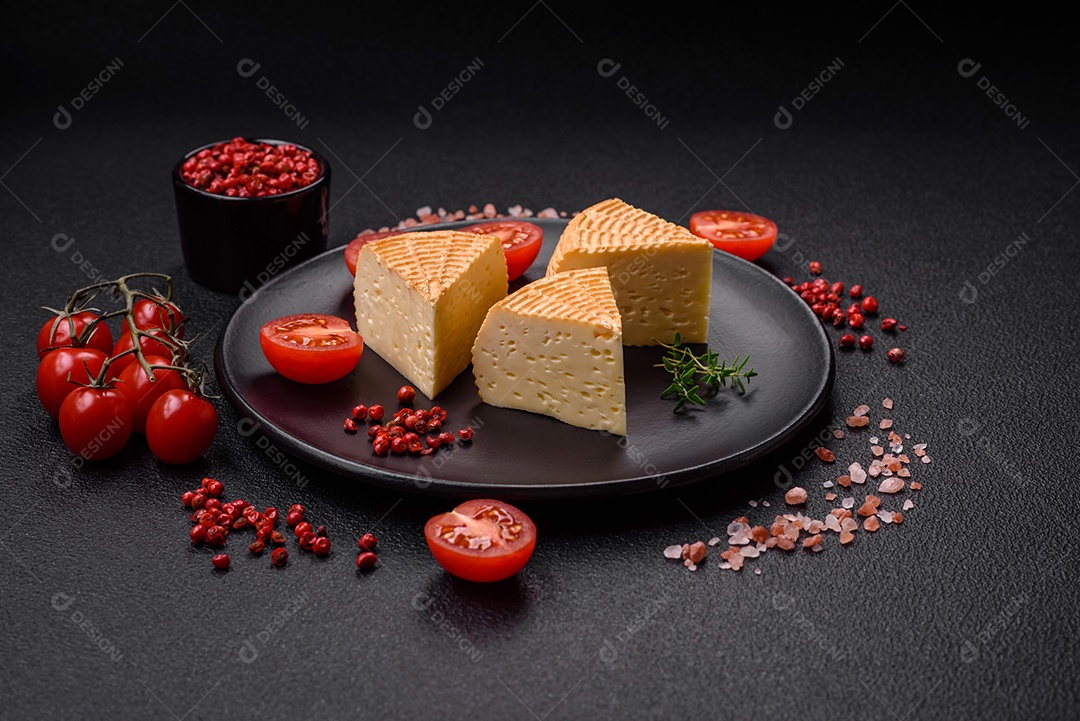 Delicioso queijo artesanal feito de leite de vaca ou cabra sobre um fundo escuro de concreto