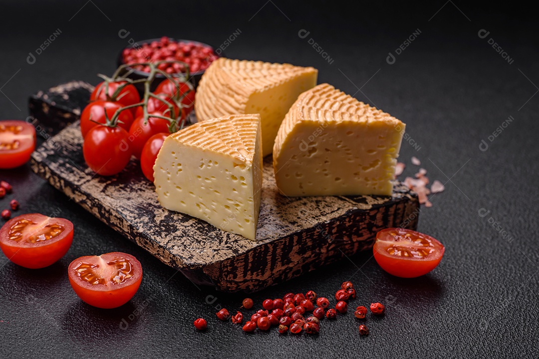 Delicioso queijo artesanal feito de leite de vaca ou cabra sobre um fundo escuro de concreto