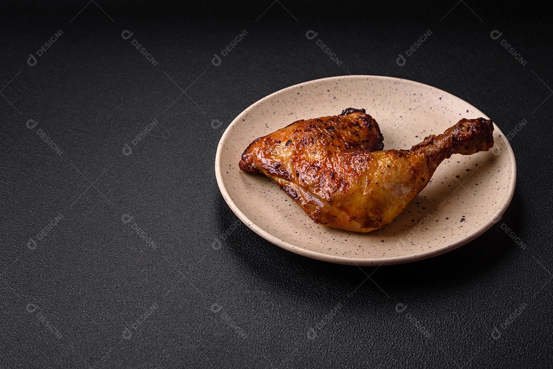 Deliciosa coxa ou quarto de frango grelhado com sal e especiarias em fundo escuro de concreto