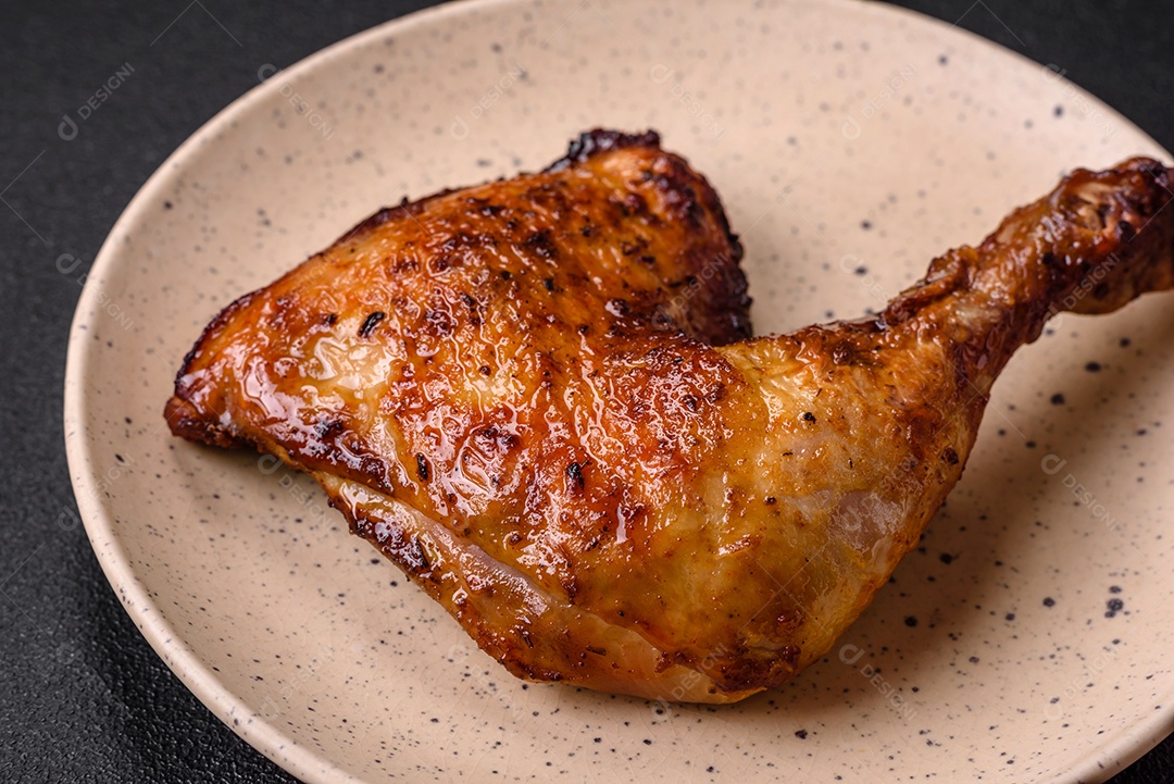 Deliciosa coxa ou quarto de frango grelhado com sal e especiarias em fundo escuro de concreto