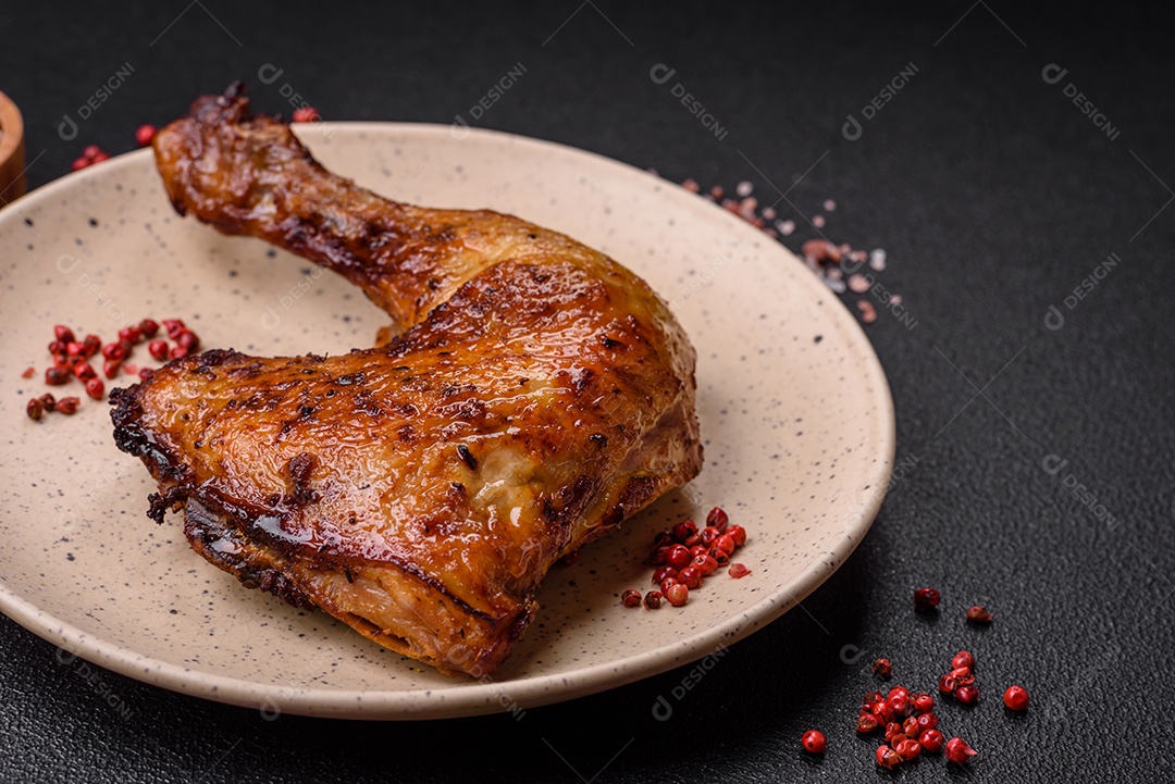 Deliciosa coxa ou quarto de frango grelhado com sal e especiarias em fundo escuro de concreto