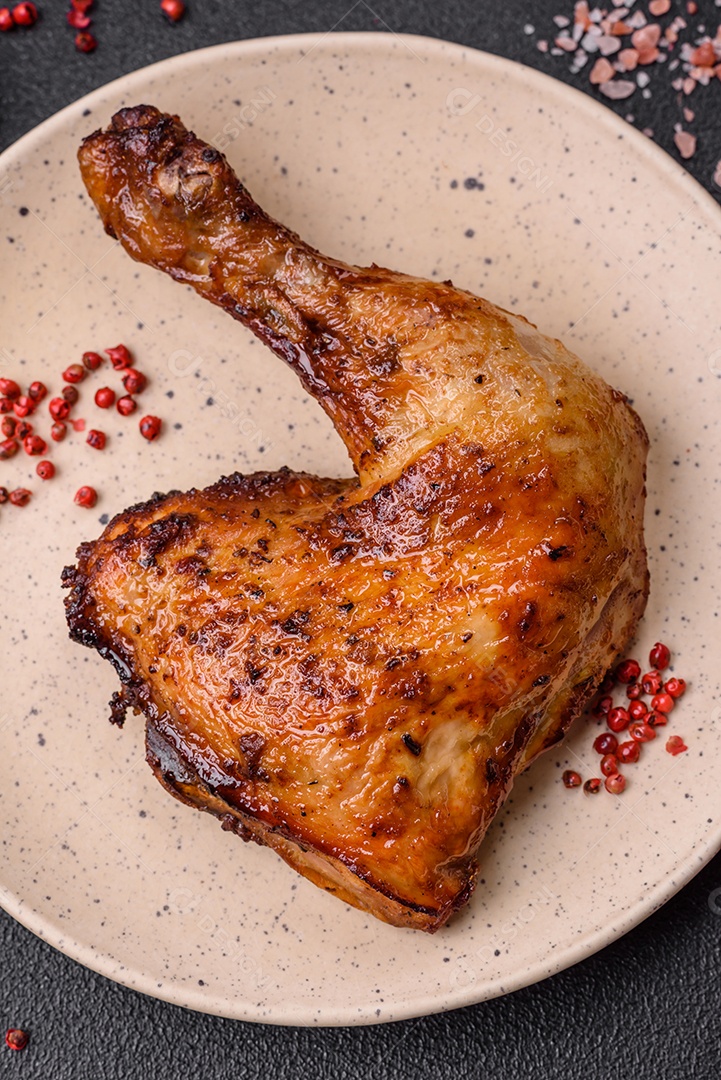 Deliciosa coxa ou quarto de frango grelhado com sal e especiarias em fundo escuro de concreto