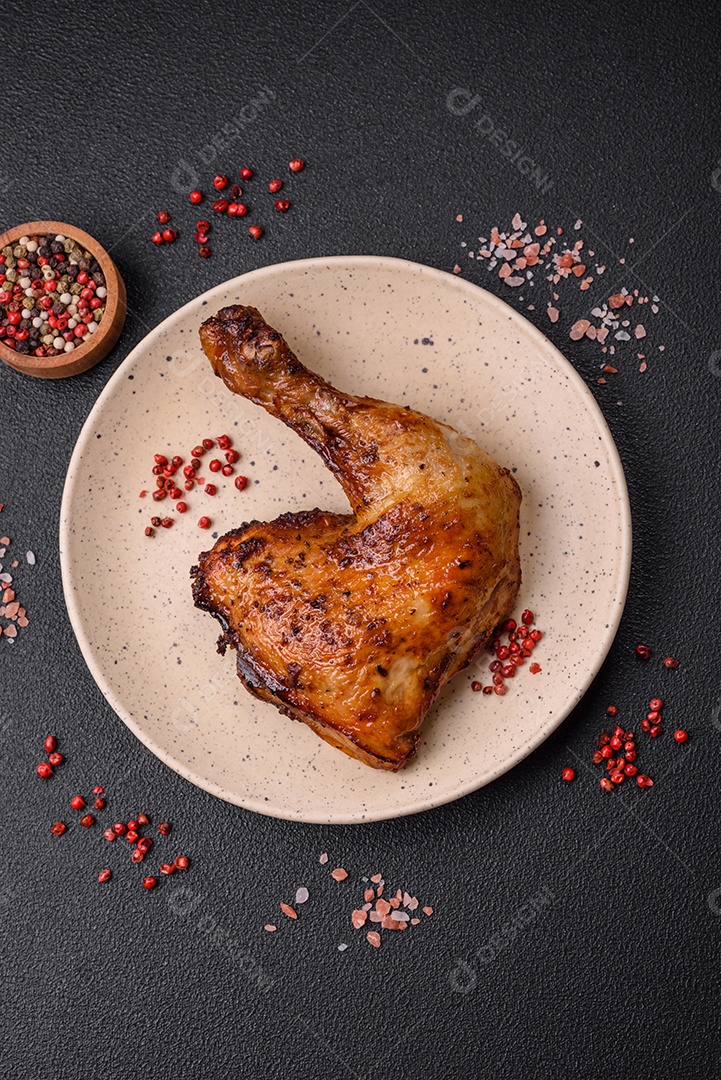 Deliciosa coxa ou quarto de frango grelhado com sal e especiarias em fundo escuro de concreto