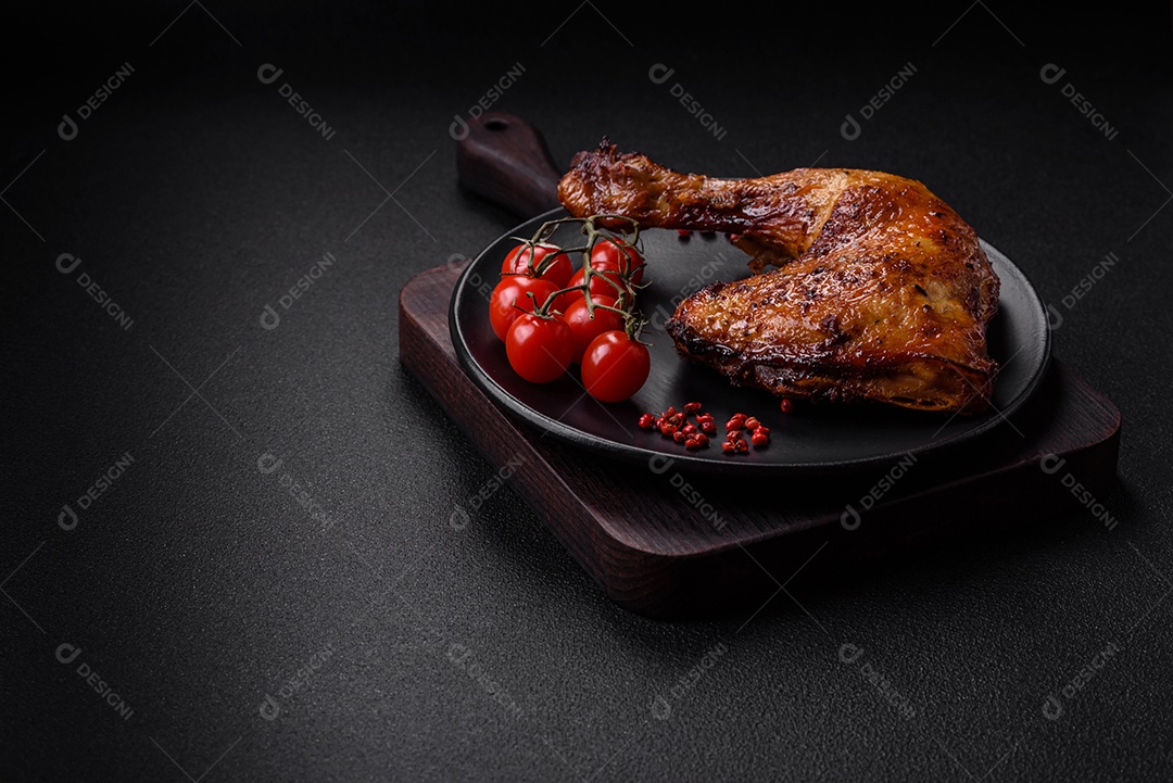 Deliciosa coxa ou quarto de frango grelhado com sal e especiarias em fundo escuro de concreto