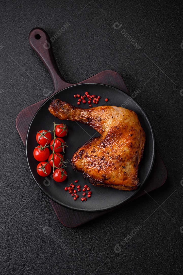 Deliciosa coxa ou quarto de frango grelhado com sal e especiarias em fundo escuro de concreto