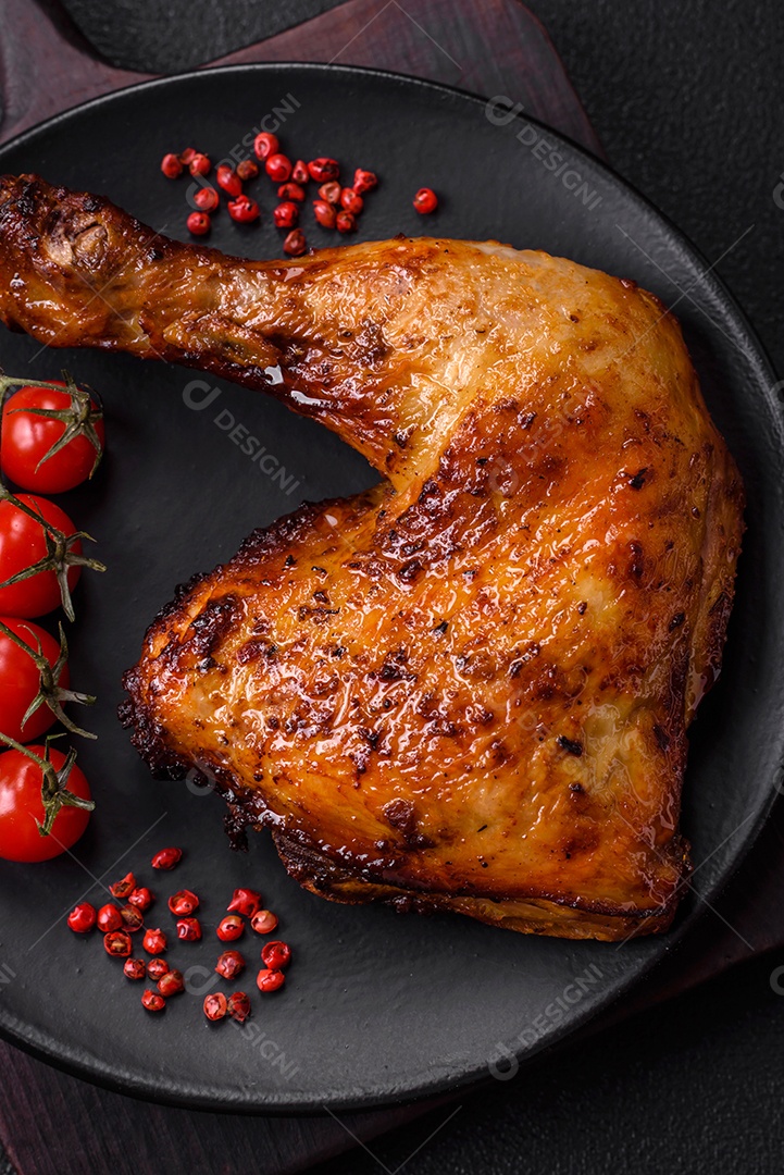 Deliciosa coxa ou quarto de frango grelhado com sal e especiarias em fundo escuro de concreto