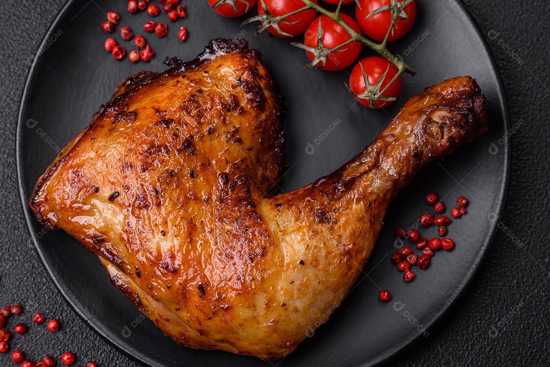 Deliciosa coxa ou quarto de frango grelhado com sal e especiarias em fundo escuro de concreto