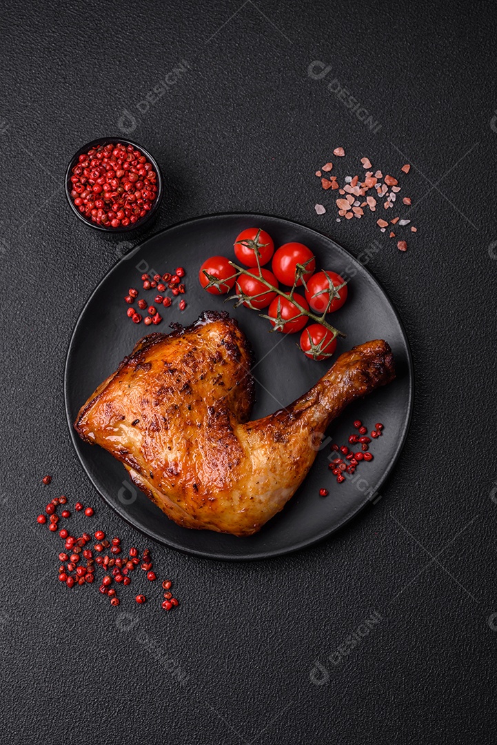 Deliciosa coxa ou quarto de frango grelhado com sal e especiarias em fundo escuro de concreto