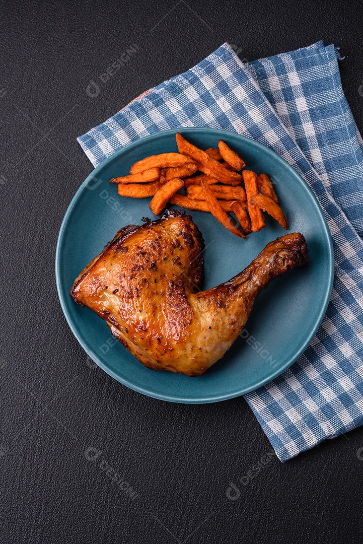 Deliciosa coxa ou quarto de frango grelhado com sal e especiarias em fundo escuro de concreto