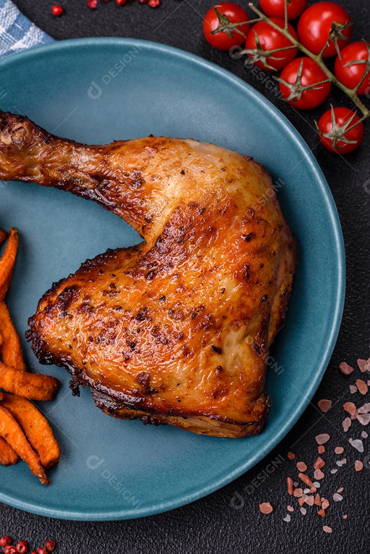 Deliciosa coxa ou quarto de frango grelhado com sal e especiarias em fundo escuro de concreto
