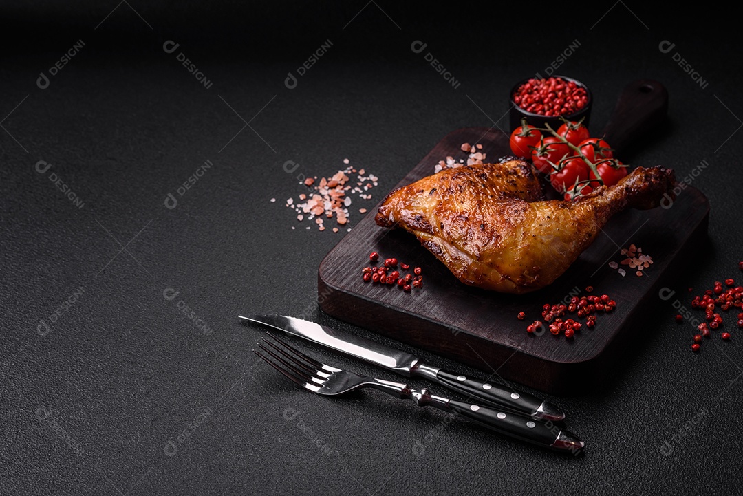 Deliciosa coxa ou quarto de frango grelhado com sal e especiarias em fundo escuro de concreto