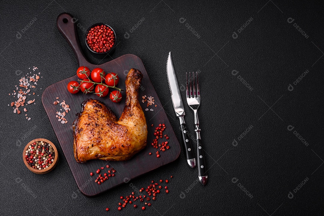 Deliciosa coxa ou quarto de frango grelhado com sal e especiarias em fundo escuro de concreto