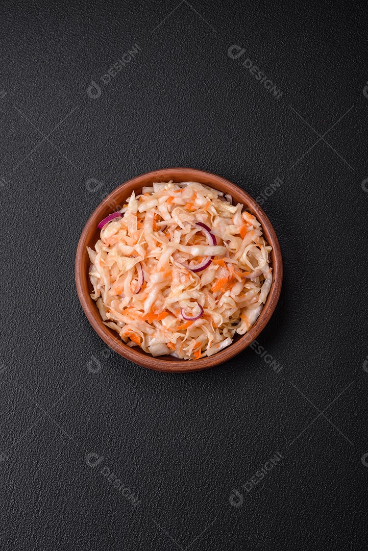 Delicioso repolho salgado em conserva com cenoura, sal e especiarias num prato de cerâmica