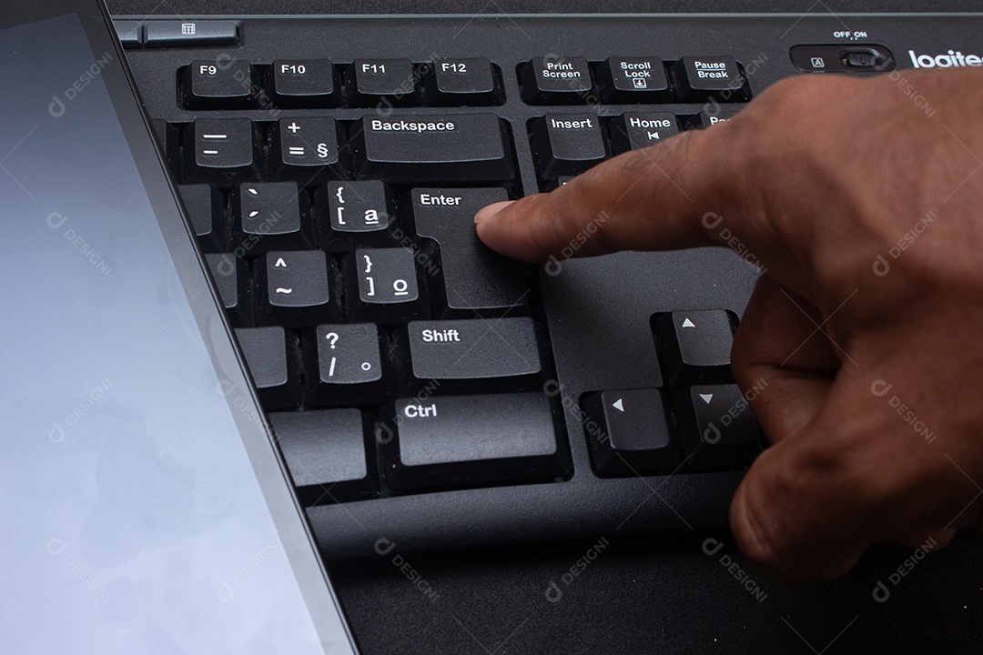 Mão digitando no teclado perto da mesa