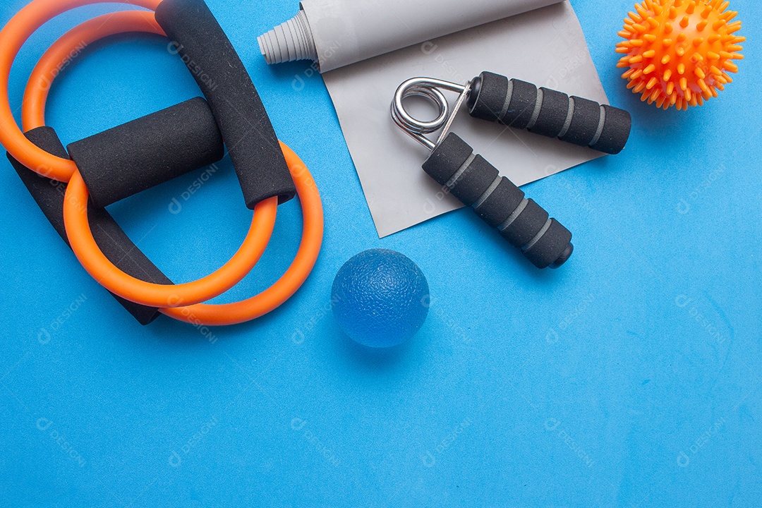 Mini bola elástico e outros equipamentos de ginástica em um fundo azul