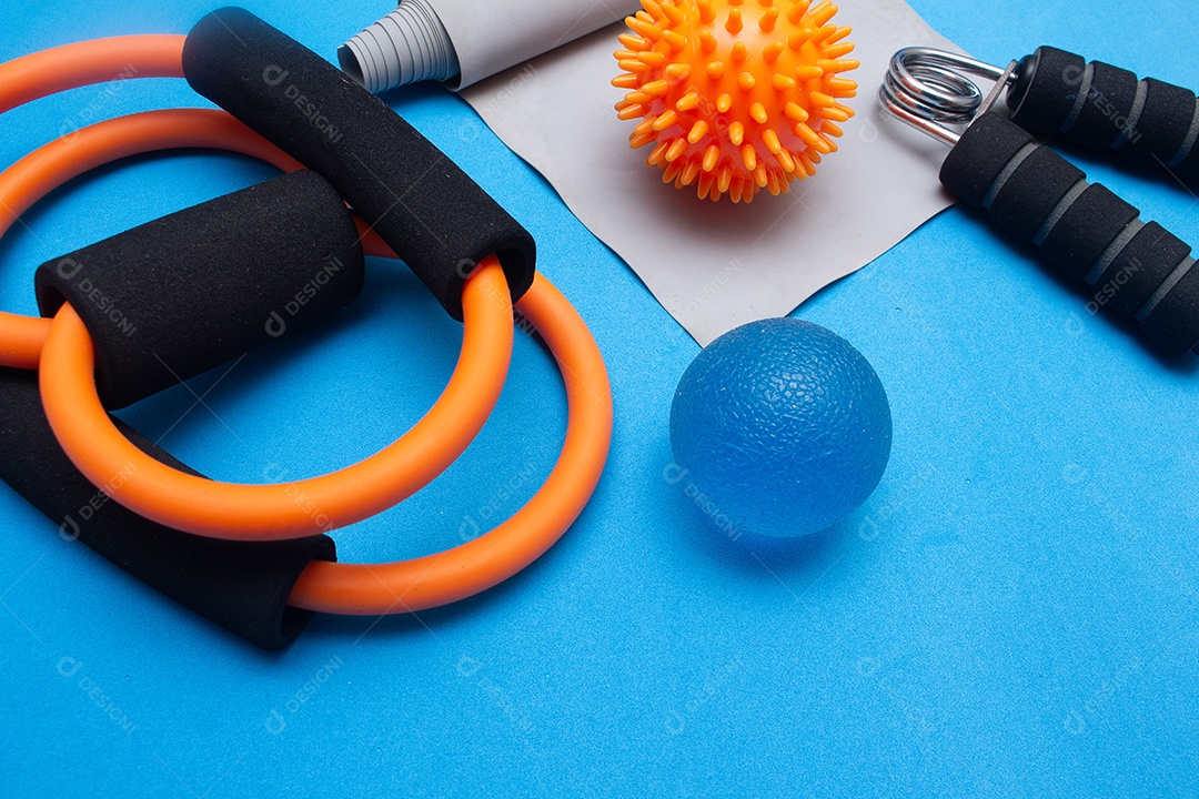 Mini bola elástico e outros equipamentos de ginástica em um fundo azul