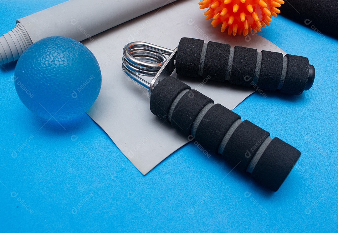 Mini bola elástico e outros equipamentos de ginástica em um fundo azul