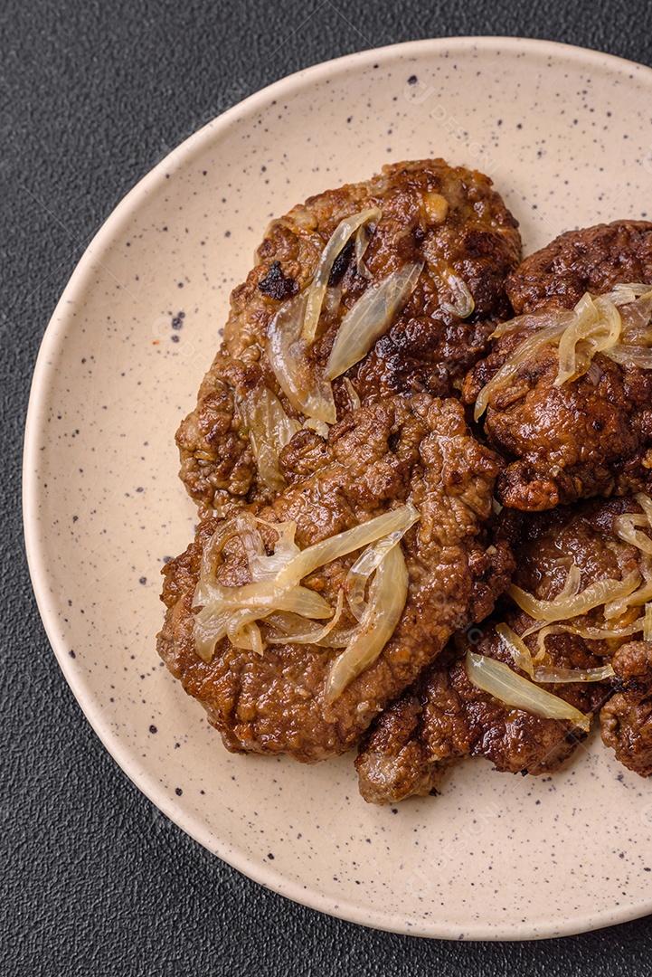 Delicioso frango frito ou fígado bovino com sal, especiarias e ervas em um prato de cerâmica